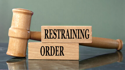 RESTRAINING ORDER - words on wooden blocks with a judge's gavel in the background