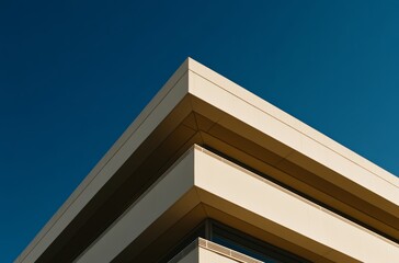 A sharp-edged modern building corner juts out against a pristine blue sky, showcasing architectural design and urban beauty
