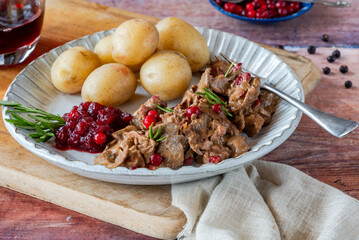 Traditional Norwegian reindeer stew with lingonberries and boiled potatoes