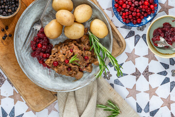 Traditional Norwegian reindeer stew with lingonberries and boiled potatoes