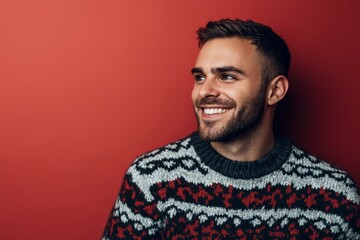 Obraz premium A cheerful man in a patterned sweater beams joyfully, creating a lively and engaging winter mood in a bright setting