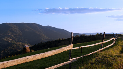 Mountain agricultural summer landscape at sunset.