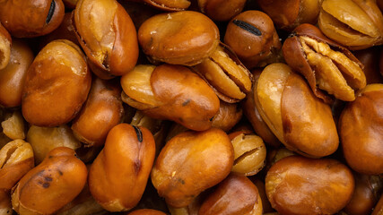 roasted broad beans with salt fill the entire frame. background photo in 16x9 format. top view
