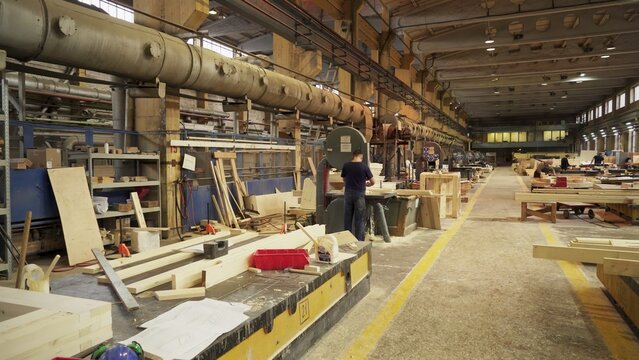 The interior of a bustling woodworking workshop featuring various machinery and raw materials. Stock Clip