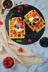 still life Belgian waffles on a black round plate