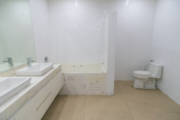 baño de departamento iluminado con lavabo , inodoro y  tina para baño