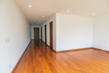 amplia sala de departamento vacio con piso de madera