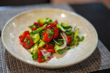 photo depicts a fresh vegetable salad featuring tomatoes, cucumbers, purple onions