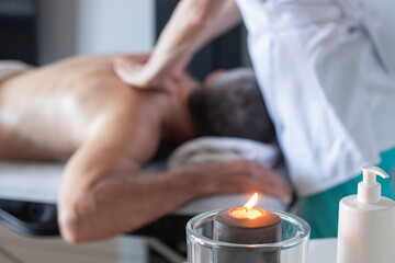 Man receiving back massage from masseur in spa