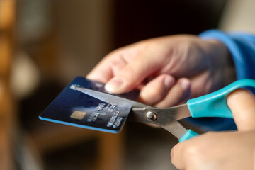 Cutting credit card with scissors. 