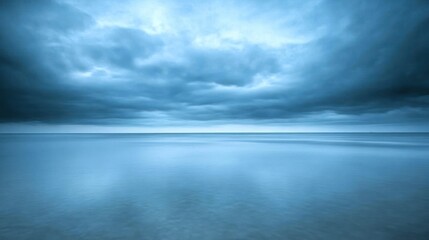 Obraz premium A calm and serene ocean scene under a dramatic sky with clouds.