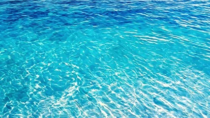 Surface of tranquil turquoise water with sunlight reflections, creating a peaceful atmosphere along the coastline