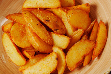Golden potato wedges, perfectly seasoned and golden, are artfully arranged in a charming bowl