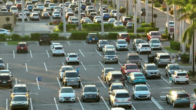 Shopping mall parking lot with many customer cars parked on large plaza in Florida. American consumerism concept