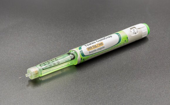 Sanofi Toujeo SoloStar insulin pen injection closeup on black.