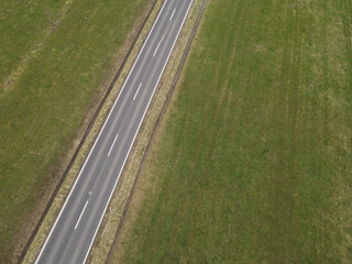 Aerial view of a road between farm fields in the countryside in spring
