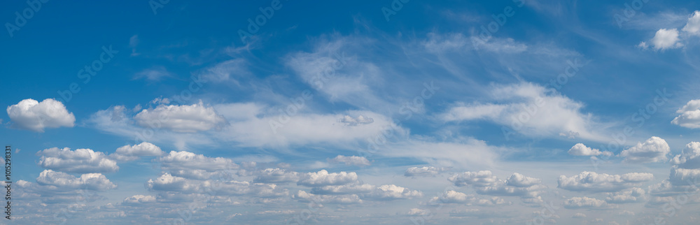 Poster the sky is blue and filled with clouds. the clouds are scattered throughout the sky, with some close