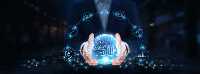 ISO: Businessman hands hold global ISO technology, standards, compliance, quality management, risk...