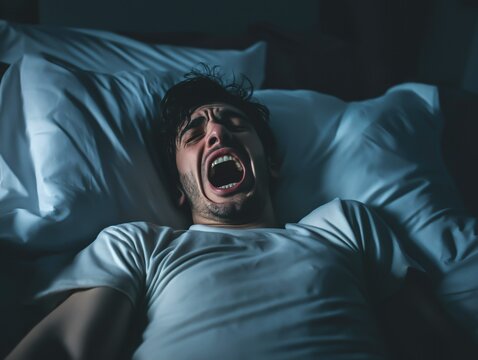 Jovem acordando na madrugada com pesadelos. Imagem que fala sobre dist&uacute;rbios do sono