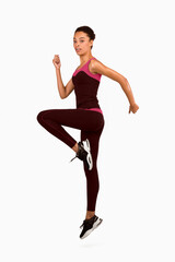 Fitness And Workout. Afro Girl Jumping Exercising During Sport Training Looking At Camera On White Studio Background. Vertical, Full Length