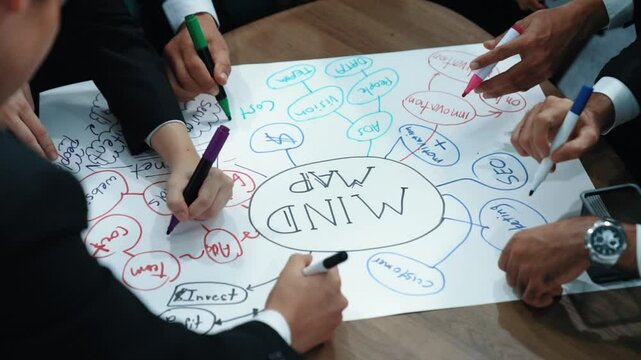 Top view of skilled diverse business people planning project by using mind map to brainstorm marketing idea. Closeup of smart start up team working together to draw creative mind map. Directorate.