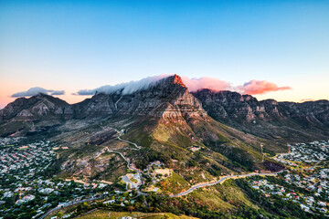 Naklejka premium Cape Town Sunset over Camps Bay Beach with Table Mountain and Twelve Apostles in the Background