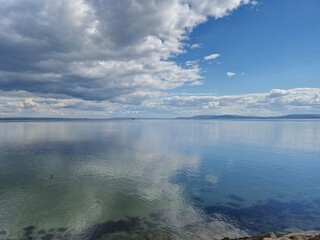 Serene Irish Seaside: Ocean Embankment with Clear Waters and Cloud Reflections
