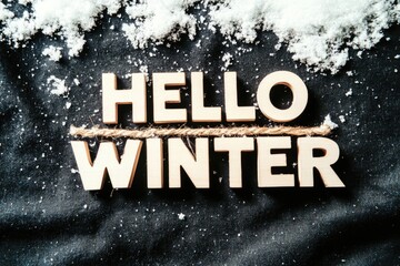 Fototapeta premium Hello winter: wooden letters on snowy black background