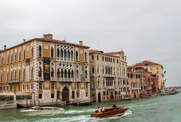 Venice, Italy - 1 October 2024: Grand Canal with Historical Buildings and Boats. View of historical buildings along the Grand Canal, with motorboats and water taxis navigating the waterway.