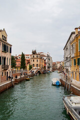 Picturesque Venetian Canal with Bridge and Colorful Buildings. Venetian canal scene with a charming bridge, colorful historic buildings, boats, and tranquil waterway.