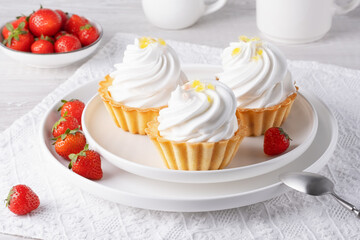 Baskets with protein cream and strawberries on a white table