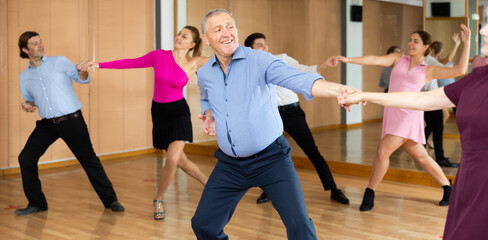 Professional mature male dancer rehearsing ballroom dances in dance studio