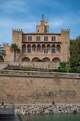 Fototapeta premium The Royal Palace of La Almudaina in Palma de mallorca with trees and lake in front, vertical shot, Majorca