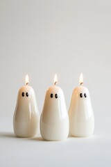  Three candles in a row on a white background, illuminated by two flames