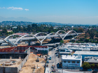 The iconic Sixth Street Viaduct with wave like arches spans a busy urban area in Los Angeles, with...