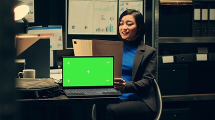 Forensic expert examines case evidence next to greenscreen on pc display, reading federal...