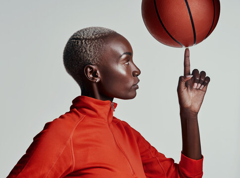 Studio, black woman and finger with basketball for sport, balance and trick for competition game. Fitness, female person and professional player with practice for spinning, skills or white background - Powered by Adobe