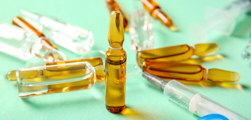 Ampules, bottle with medicines and syringe on turquoise background