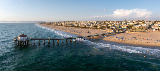 Aerial perspective of Manhattan Beach, California, highlighting the iconic pier, sandy beach with...
