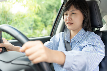 Woman use seatbelt and drives with intent, safe driving, driving practice, cheerful woman sits comfortably in the driver's seat with her hand confidently , readiness for a journey