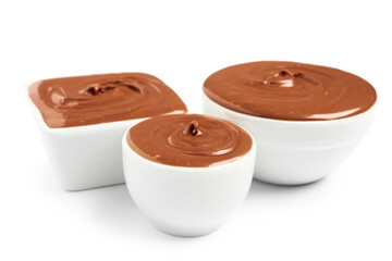 Bowls of tasty melted chocolate on white background