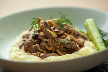 Tender beef and earthy mushrooms in a creamy sauce over mashed potatoes, garnished with fresh dill. Hearty beef stroganoff, perfect for lunch or dinner