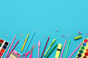 Watercolor paints, calculator and scissors on blue background. Top view