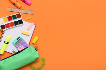 Different stationery on orange background. Top view