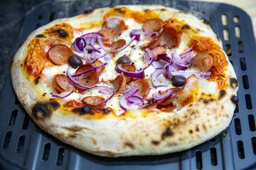 Rustic artisanal pepperoni pizza with red onion