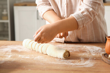 Woman preparing traditional cinnamon rolls in kitchen © Pixel-Shot