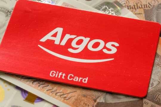 Argos gift card close-up on British currency. Retail shopping concept showcasing digital gift cards and consumer spending in the UK. Stafford, United Kingdom, October 6, 2024.