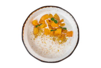 Oatmeal with milk served with fresh apricot on a white background top view