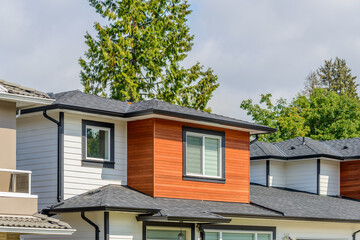 A perfect neighborhood. Houses in suburb at Fall in the north America. Top of a luxury house with nice window over blue sky.