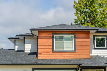 A perfect neighborhood. Houses in suburb at Fall in the north America. Top of a luxury house with nice window over blue sky.